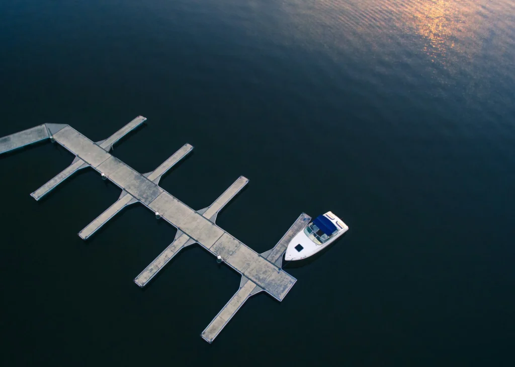 A dock with a single boat floating on calm waters during sunset in Mount Dora, Florida.
