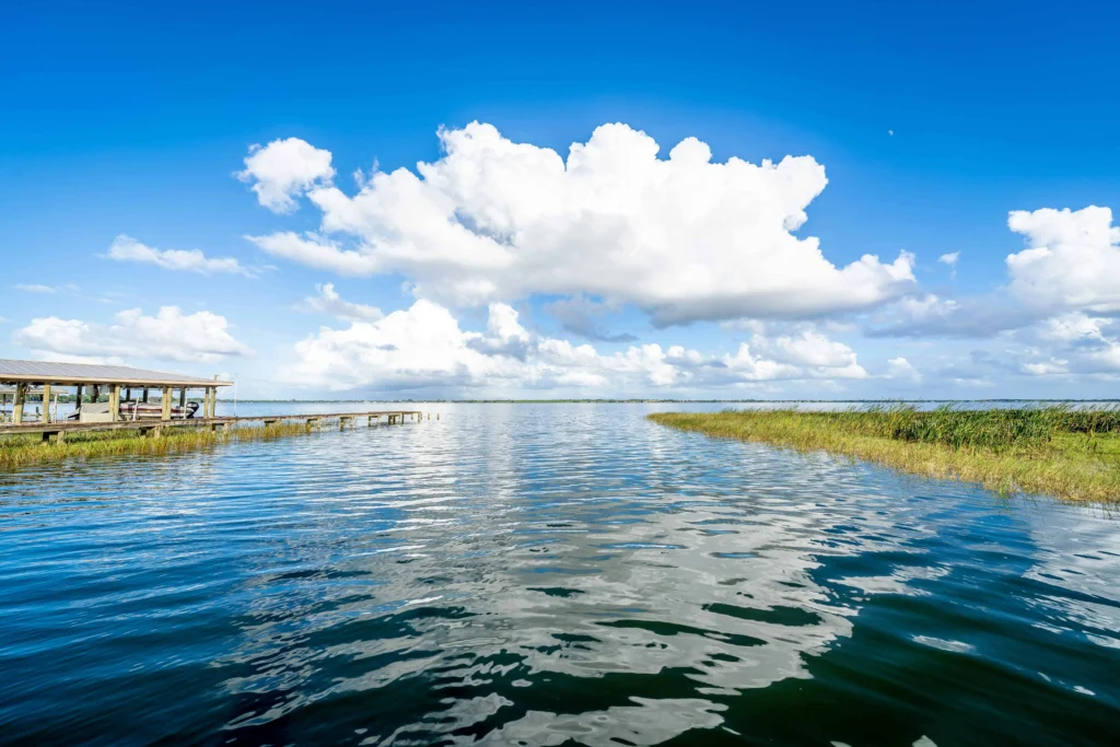 Calm waters of Lake Placid with a wooden dock under a clear blue sky.