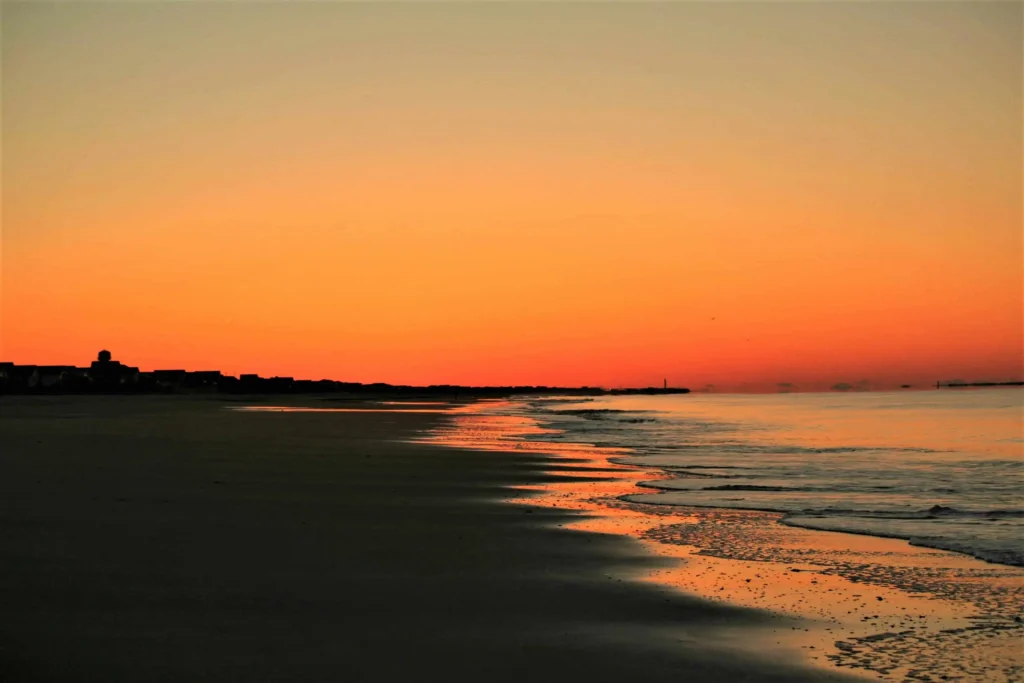 A golden sunset over the shoreline of Oak Island, NC.