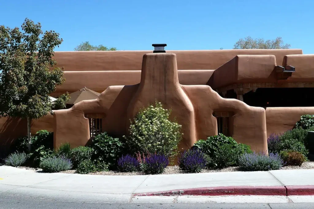 Traditional adobe building surrounded by vibrant greenery in Santa Fe