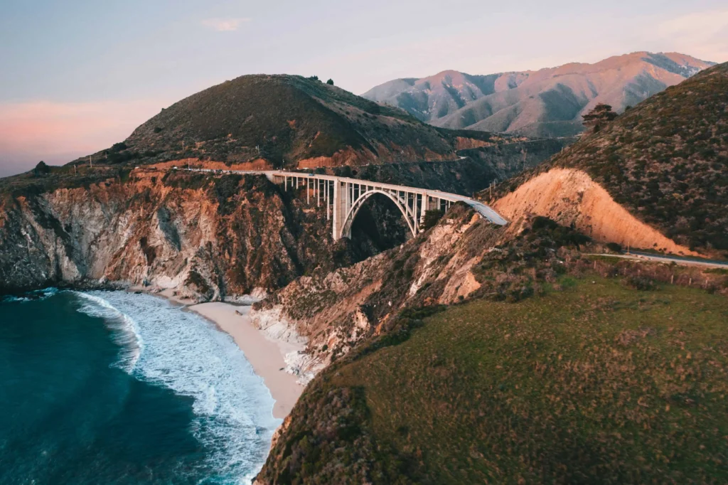 Bixby Bridge illuminated by the sunset, overlooking the Pacific Ocean.