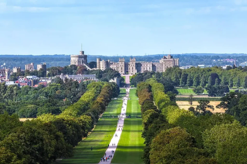 A breathtaking view of the Long Walk leading to Windsor Castle, surrounded by lush greenery.