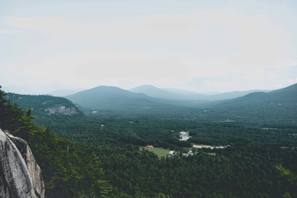 A breathtaking panoramic view of the White Mountains in North Conway, NH, with lush forests and distant peaks.
