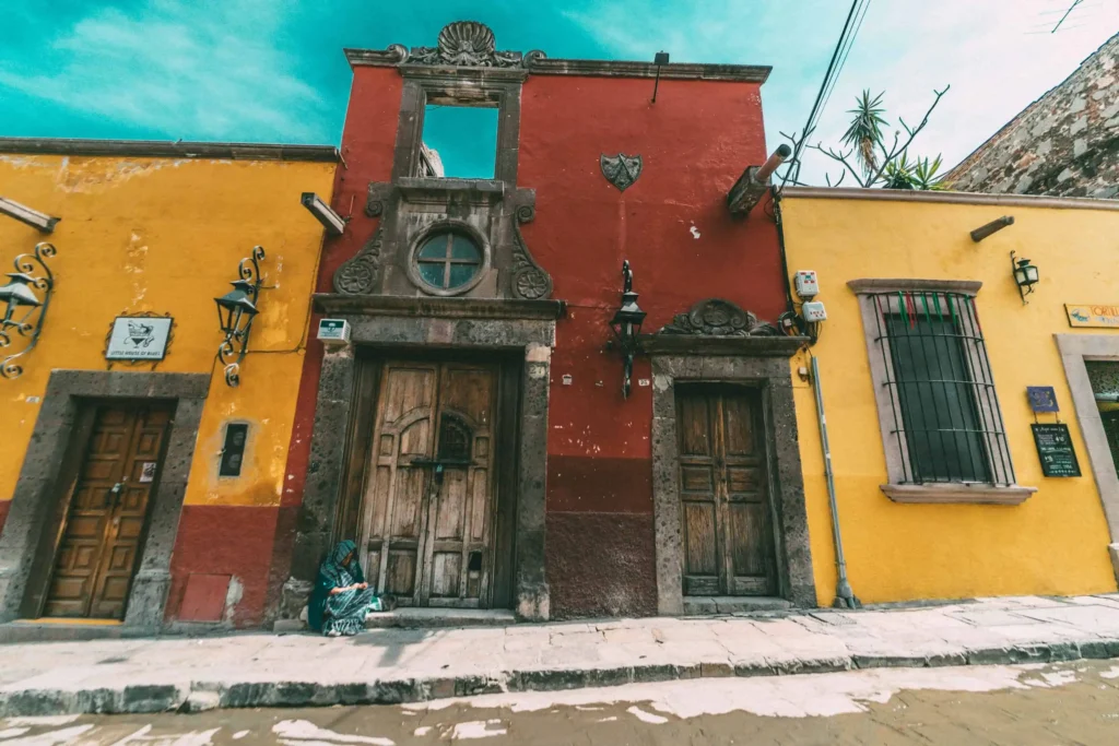 A rustic colonial-style building with colorful walls and wooden doors.