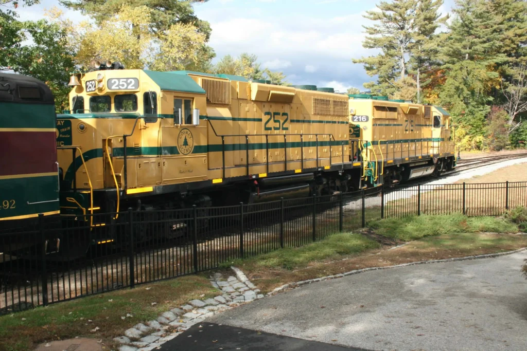 A bright yellow Conway Scenic Railroad locomotive parked at the station in North Conway, NH.